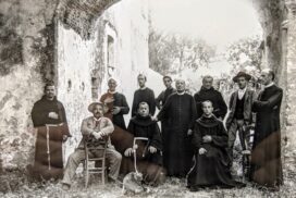 Un gruppo di frati, sacerdoti e laici fotografati sotto un porticato